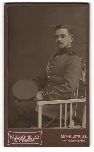 Fotografie Paul Schindler, Wittenberg Mittelstrasse 58, Sitzender Soldat des 20. Rgts. in Uniform mit Schützenschnur