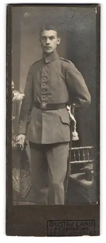 Fotografie Gustav Lang, Regensburg, Weisse Lilienstrasse 13, Schlaksiger Soldat in Feldgrau mit Portepee am Bajonett