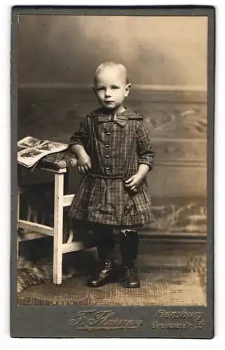 Fotografie F. Flarup, Flensburg, Grossestr. 75, Kind im karierten Kleid mit Schleife