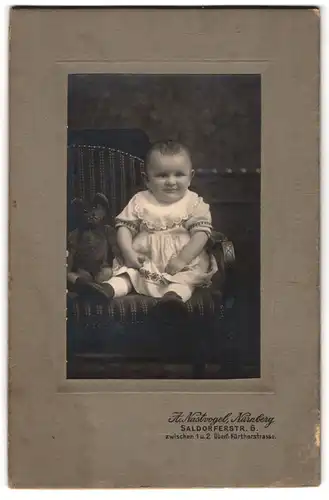 Fotografie A. Nastvogel, Nürnberg, Salzdorferstrasse 6, Fürtherstrasse, Lächelndes Kleinkind mit Teddy