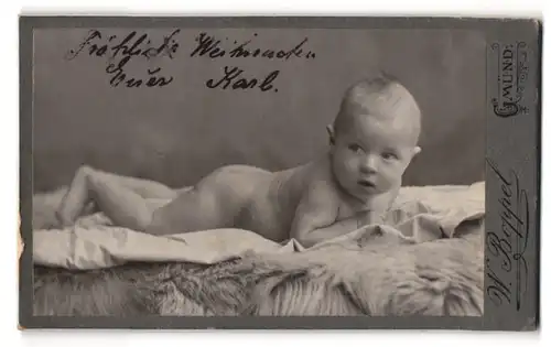 Fotografie Wilh. Boppel, Gmünd, Nackiges Kleinkind liegt bäuchlings auf einem Laken