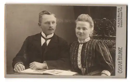 Fotografie Oskar Brunke, Flensburg, Grosse Str. 15-19, Junges Paar in hübscher Kleidung mit Buch