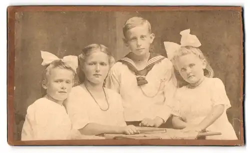 Fotografie M. B. Schultz, Flensburg, Junge im Matrosenhemd mit drei Mädchen