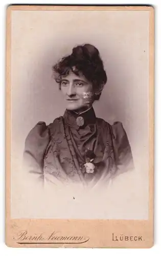 Fotografie Bernh. Neumann, Lübeck, Sandstrasse 19, Dame mit kunstvoller Frisur und Brosche