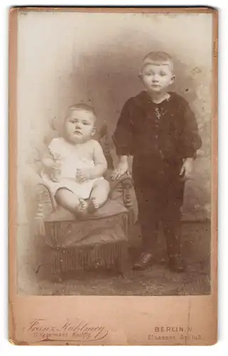 Fotografie Franz Kuhlmey, Berlin N., Elsasser-Strasse 1 u. 2, Baby auf einem Sessel und kleiner Junge im Anzug
