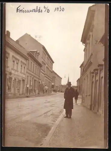 Fotografie unbekannter Fotograf, Ansicht Freienwalde a. O., Strassenansicht mit Ladengeschäften, Kirchturm im Hintergrund