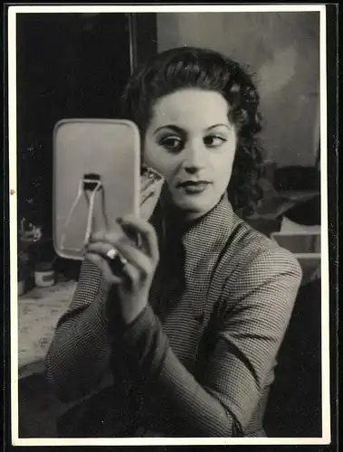 Fotografie Lomont, Hamburg, hübsche Brünette Dame schminkt sich mit einem kleinen Spiegel