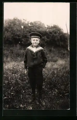 AK Junge im Matrosenaufzug mit Mütze mit Aufschrift Gross Kampfschiff