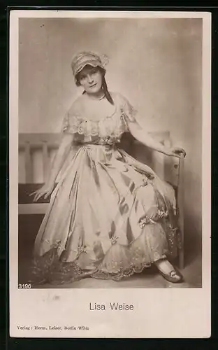 AK Schauspielerin Lisa Weise mit Mütze auf einer Bank sitzend