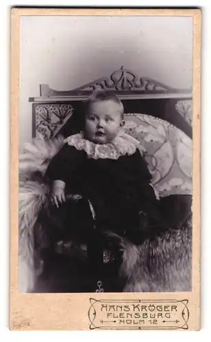 Fotografie Hans Kröger, Flensburg, Holm 12, Portrait niedliches Baby auf einem Fell sitzend
