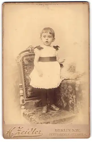 Fotografie H. Zeidler, Berlin S.W., Jerusalemer-Strasse 6, Kleines Kind mit kurzen Haaren im Spitzenkleidchen