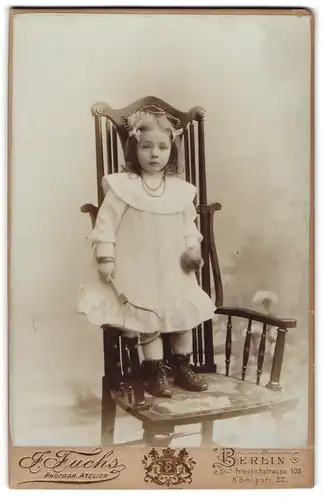Fotografie J. Fuchs, Berlin, Friedrichstrass3 108, Kleines Mädchen mit Tennisschläger auf einem Stuhl stehend