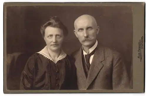 Fotografie Rud. Oberst, Salzwedel, Ehepaar im mittleren Alter fein herausgeputzt