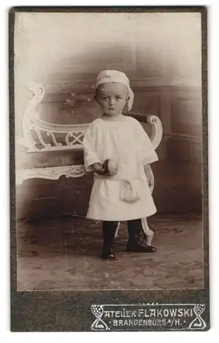 Fotografie Atelier Flakowski, Brandenburg a /H., Kleiner Junge im Kleid mit einem Ball