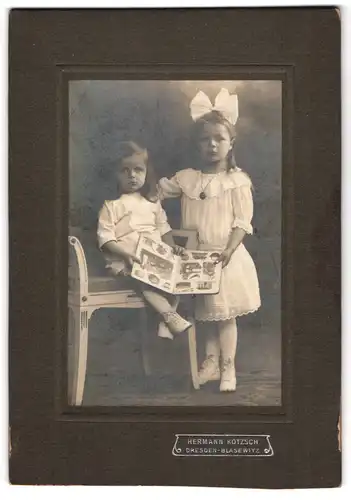 Fotografie Hermann Kotzsch, Dresden-Blasewitz, Zwei kleine Mädchen im Sonntagsstaat mit einem Bilderbuch