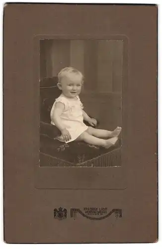 Fotografie Friedrich Looff, Dresden-Weinböhla, Göthestrasse 27, Lächelndes Baby auf einem Sessel