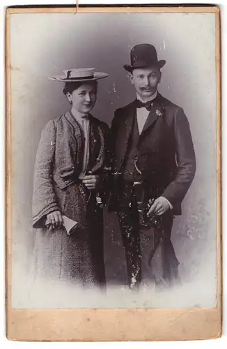 Fotografie unbekannter Fotograf und Ort, Elegantes junges Paar mit Hüten