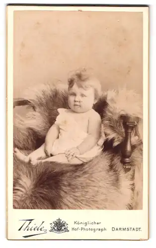 Fotografie Hugo Thiele, Darmstadt, Wilhelminen-Str. 6, Süsses Kleinkind im Hemd sitzt auf Fell