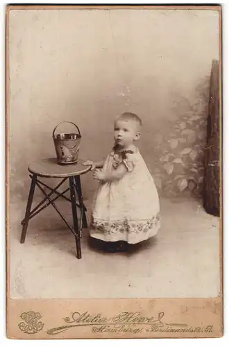 Fotografie Atelier Howel, Hamburg, Ferdinandstrasse 51, Kind mit kurzen Haaren im Kleidchen, mit Spieleimer