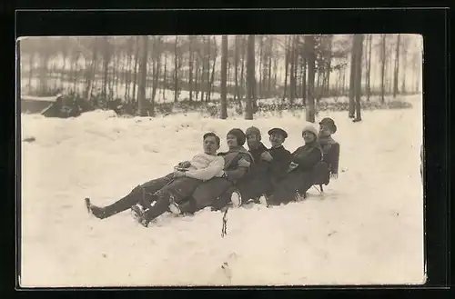 Foto-AK Gruppe Menschen beim gemeinsamen Schlitten Fahren