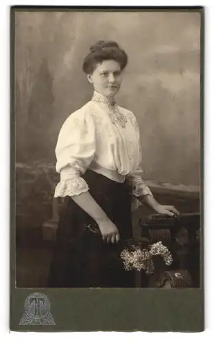 Fotografie Hermann Tietz, Berlin, Leipzigerstr. 46-50, Portrait brünette Schönheit mit Blumen in der Hand