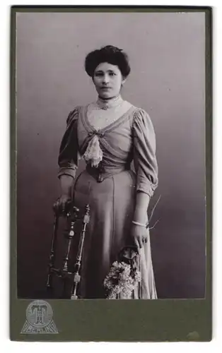 Fotografie Hermann Tietz, Berlin, Leipzigerstr. 46-50, Portrait dunkelhaarige Schönheit mit Blumen in der Hand