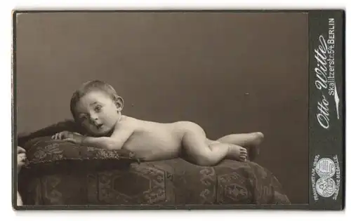 Fotografie Otto Witte, Berlin, Skalitzerstr. 54, Portrait nacktes Baby liegt auf einer bestickten Decke