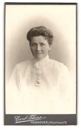 Fotografie Carl Thies, Hannover, Höltystr. 13, Portrait dunkelhaarige schöne Frau in Bluse mit Blumenbrosche