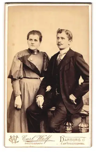 Fotografie Carl Wolf, Harburg, Am Kriegerdenkmal, Portrait eines elegant gekleideten Paares