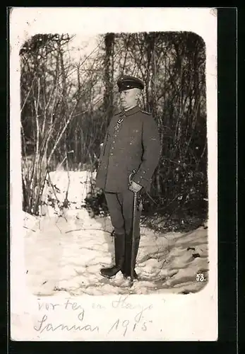 Foto-AK Soldat in Uniform mit Schirmmütze und Orden Eisernes Kreuz im Schnee, Uniformfoto