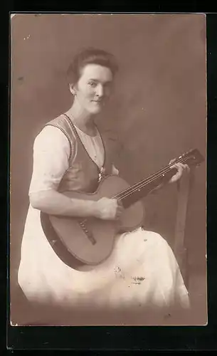 AK Junge Frau sitzt in ihrem Kleid und spielt auf ihrer Gitarre