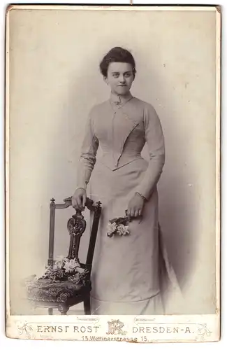 Fotografie Ernst Rost, Dresden, Wettinerstr. 15, Junge Frau mit denklem Haar trägt helles Kleid und hält Blumen