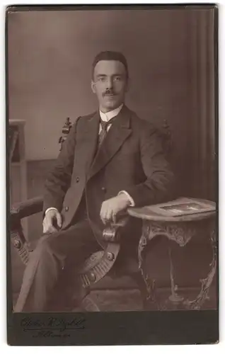 Fotografie R. Przibill, Altona, Sitzender Herr in Anzug trägt eine gemusterte Krawatte