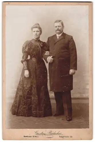 Fotografie Gustav Bödecker, Hamburg, Reeperbahn 130, Herr in langem Mantel und Dame in besticktem Kleid Arm in Arm