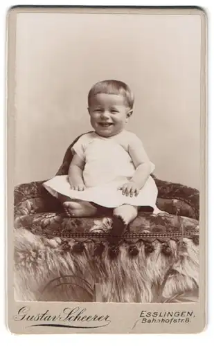 Fotografie Gustav Scheerer, Esslingen, Bahnhofstr. 8, lächelndes Kleinkind auf edler Couch