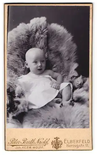 Fotografie Peter Barth Nachf., Elberfeld, Herzogstr. 11, Süsses Kleinkind im Hemd sitzt auf Fell