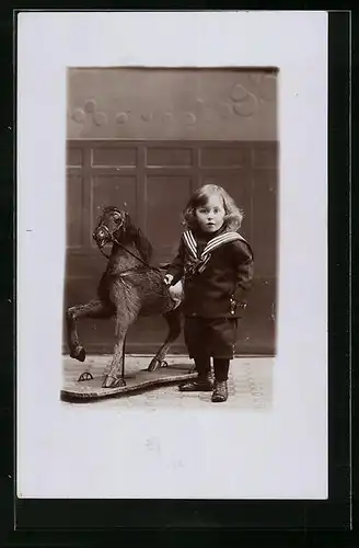 AK Kleines Mädchen im Matrosenanzug neben ihrem Schaukelpferd