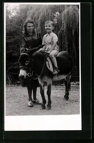 Foto-AK Mutter mit Überbiss mit Sohn beim Eselreiten