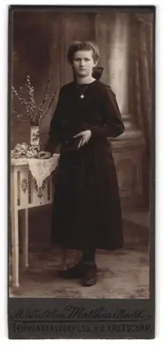 Fotografie M. Walther, Seifhennersdorf i. Sa., Traurig schauendes Mädchen im schwarzen Kommunionskleid mit Bibel