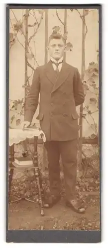 Fotografie unbekannter Fotograf und Ort, Junger Mann posiert im Garten