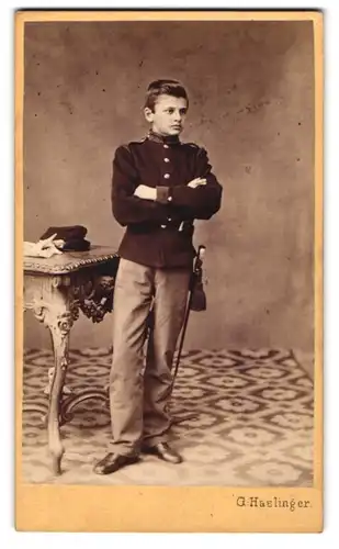 Fotografie G. Haslinger, St. Pölten, Portrait junger Knabe als Kadett in Uniform mit Säbel
