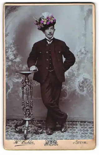 Fotografie H. Bichler, Steyr, Portrait junger Mann zur Musterung mit geschmückten Hut posiert im Atelier