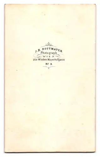 Fotografie J. B. Rottmayer, Wien, Portrait Pfarrer im Talar mit Umhand sitzend im Atelier