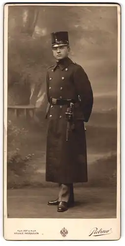 Fotografie Pietzner, Wien, junger K.u.K. Soldat in Uniformmantel mit Tschako und Bajonett, 1911