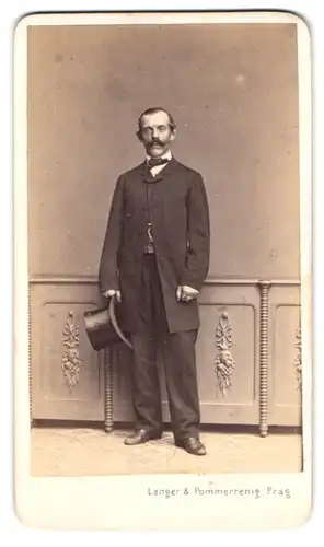 Fotografie Langer & Pommerrenig, Prag, älterer Herr im Anzug mit Zylinder in der Hand, Moustache