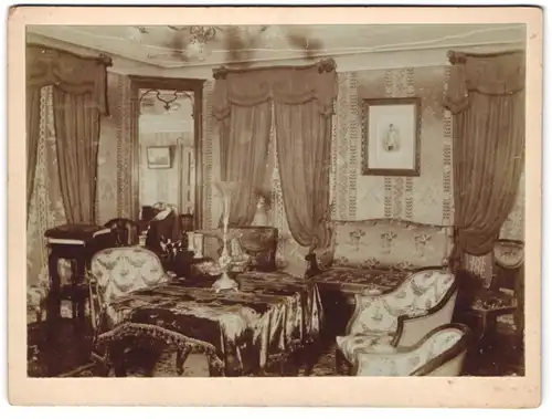 Fotografie unbekannter Fotograf und Ort, Blick in eine Wohnstube mit Polstermöbel und Etagere