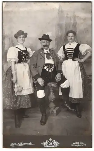 Fotografie Franz Skarwada, Wien, Schweglerstr. 20, Edelmann in Tracht von Damen in Tracht flankiert