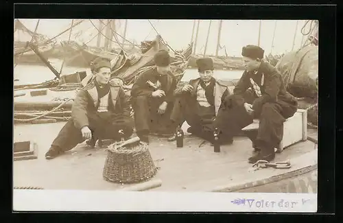 Foto-AK Volendam, Vier Niederländer, Im Hintergrund Fischerboote