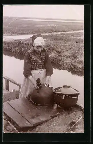 Foto-AK Mädchen in niederländischer Tracht mit Kochtopf