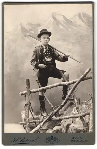Fotografie J. E. Bednarik, Wien, Kaiserstrasse 42, Junger Knirps in Lederhose vor einer traumhaften Bergkulisse, Tracht